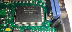 Zbliżenie na płytkę drukowaną interfejsu diagnostycznego z widocznym układem scalonym MB90F546GS firmy Fujitsu.