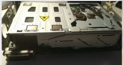 Widok na częściowo zdemontowaną zmieniarkę CD z widocznymi wewnętrznymi elementami mechanicznymi.