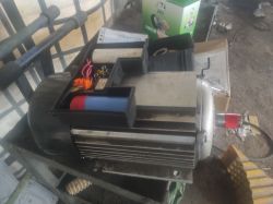 Zbliżenie na silnik elektryczny z odsłoniętymi elementami elektrycznymi w warsztacie.