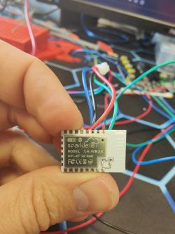 Sparkle IoT XH-WB3S V2.0 module held in hand, with colorful wires connected.