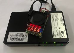 Black RouterUPS-15-POE UPS with a test module and LED display reading 13.92