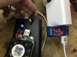 Powerbank QC test with 7% on display, voltage meter shows 7.49 V
