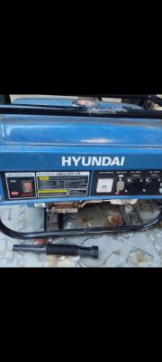 Agregat prądotwórczy HYUNDAI HG2201-PL z odłączonym czarnym przewodem leżącym przed urządzeniem.