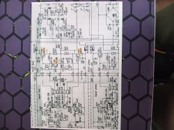 Zdjęcie kartki z wydrukowanym schematem elektronicznym z zaznaczonymi elementami i napięciami