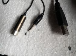 Złącza mikrofonowe: wtyk mini-jack i USB na tle styropianu.