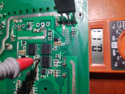 Voltage measurement on a circuit board using a multimeter.