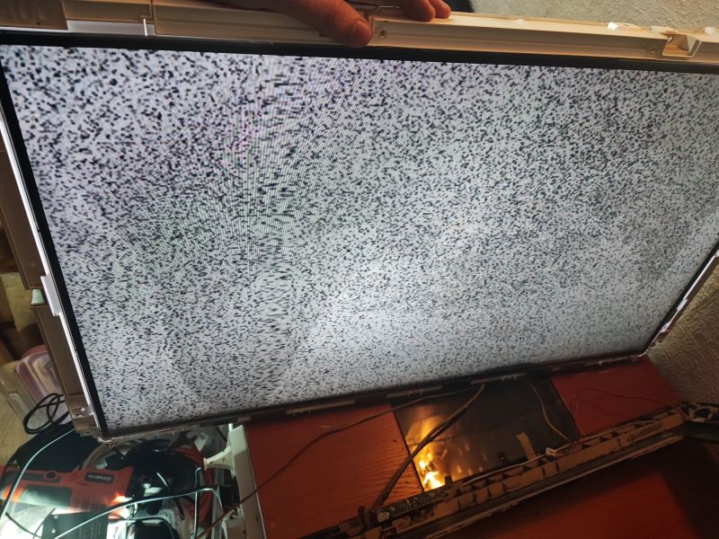 Television with Open Casing and Static Noise Television with an open casing displaying static noise.