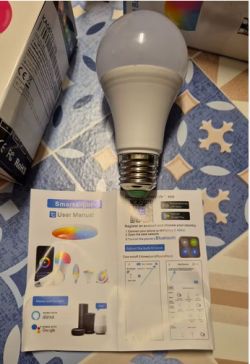 Smart LED Bulb with User Manual A smart LED bulb is on a table next to a user manual.