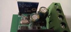 Electronic Module with Dual Switch and Terminals Close-up view of an electronic module with green terminals and a blue printed circuit board.