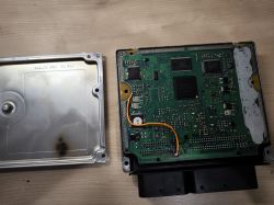 ECU z otwartą obudową i widocznymi śladami lutowania oraz uszkodzenia.