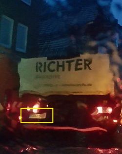 Rozmazany widok na ciężarówkę z logotypem RICHTER w deszczu.