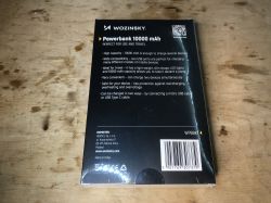 Opakowanie czarnego powerbanka Wozinsky 10000 mAh leżące na drewnianej powierzchni.