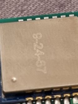 Close-up of a metallic electronic module with the marking 9-24.6 on top.