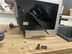 Złamana plastikowa część z metalową sprężyną obok ekspresu De'Longhi Dinamica Plus