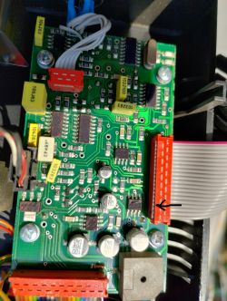 Uszkodzona płytka elektroniki wykrywacza metali Zbliżenie płytki elektronicznej z uszkodzeniem zaznaczonym strzałką.