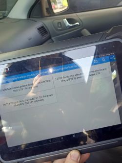 Tablet pokazujący kody błędów diagnostycznych w samochodzie.