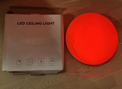 LED Ceiling Light - Red Ceiling Lamp and Its Packaging A glowing red ceiling lamp next to a box labeled LED Ceiling Light.