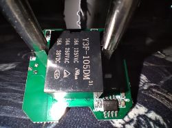 Y3F-105DM relay mounted on a green circuit board, held by metal clamps.