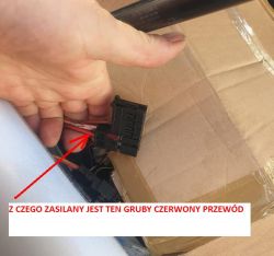 Connector with thick red wire held over cardboard, marked with arrow and label.