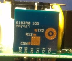 Close-up of a blue PCB labeled TX2, RX2 and GND, with a yellow wire on the right