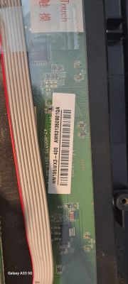 The image shows a label with a serial number and barcode on a circuit board inside a television.
