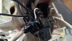 Zbliżenie na połączenia elektryczne i przewody czarno-białe w obudowie urządzenia.