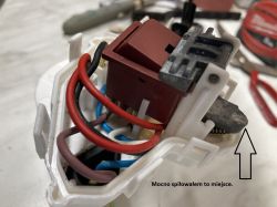 Widok zbliżeniowy na przełącznik elektryczny z kolorowymi kablami i zaznaczonym miejscem piłowania.