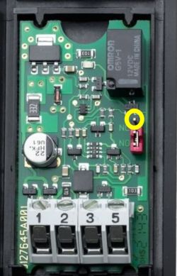 Płytka z elektroniką z oznaczonym na żółto pinem obok przekaźnika Omron