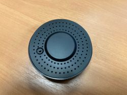 Circular Infrared Remote Black, circular infrared remote with holes and a button on top.