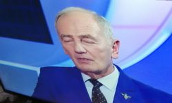 Mężczyzna w garniturze podczas transmisji telewizyjnej.
