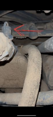 Zakurzony element pod kabiną ciągnika z zaznaczonym potencjalnym czujnikiem