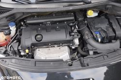 Car engine bay with engine cover, battery, air intake hose, and fluid reservoirs