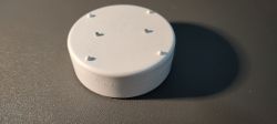 Tuya Water Leak Sensor White, round Tuya water leak sensor on a gray surface.