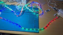Colorful LED strips arranged on a blue mat on a desk.