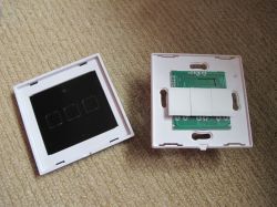 Disassembled Axus touch light switch with three touch zones, showing front panel and PCB.