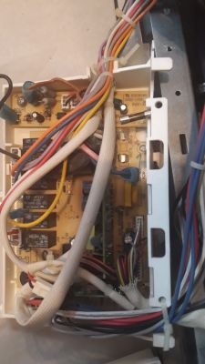 Widok wnętrza skrzynki ze sterownikiem zmywarki z widocznymi przewodami i komponentami elektronicznymi.