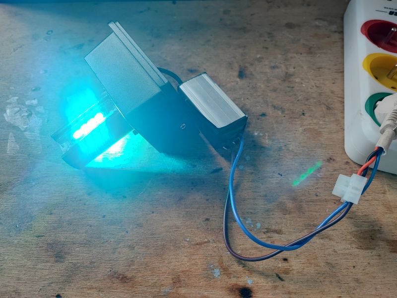 Smart LED Lamp Emitting Blue Light Smart LED lamp emitting blue light on a wooden workbench.