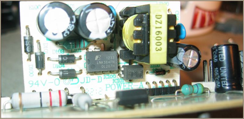 Zbliżenie na płytkę drukowaną z widocznymi elementami elektronicznymi, takimi jak kondensatory i chip LNK364PN.