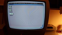 Ekran telewizora CRT wyświetlający zakłócony obraz interfejsu Workbench systemu Amiga.