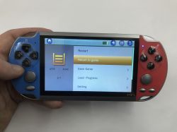 Handheld X12 console in hand; screen shows menu with Restart and Save Game options