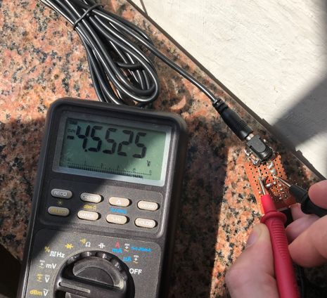 Zbliżenie panelu słonecznego 15W ustawionego na balkonie z podłączonym powerbankiem do testów ładowania.