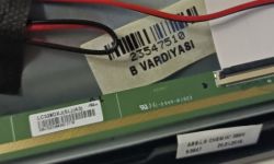 Close-up of a barcode label and markings on a circuit board.