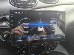 Ekran radia samochodowego z systemem Android, pokazujący czas i różne aplikacje.