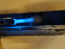 Torch flame directed at a fireplace panel.