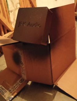 Malowana czarna obudowa z napisem „JRK Audio” susząca się na dużym kartonie.