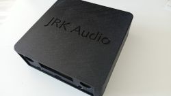 Czarna obudowa amplitunera JRK Audio z wytłoczonym napisem na górnej części.