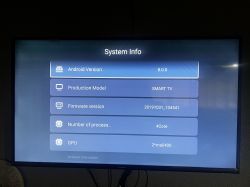 Smart TV screen displaying system information, showing Android version 8.0.0, production model, firmware version, number of processors, and GPU.