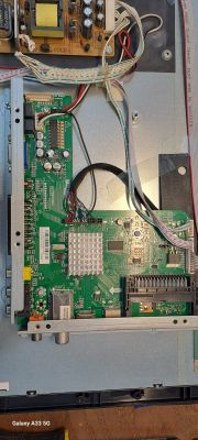Close-up of the inside of a TV case revealing the main board and electronic components.