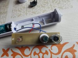 Rozebrana lampka z widocznym układem elektronicznym, baterią i czujnikiem zmierzchu/ruchu.