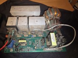 Zdjęcie wewnętrznej elektroniki migomatu z widocznymi płytkami i elementami elektronicznymi w szarym odcieniu.